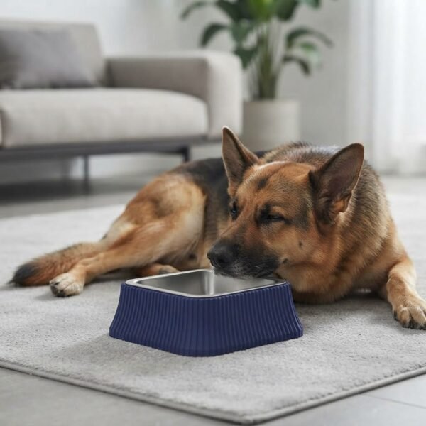 A large German Shepherd is lying down beside the PetzVibes Anti-Tip Stainless Steel Dog Bowl in Dark Blue, square shape, placed on a light grey area rug in a minimalist living room petzvibes.com